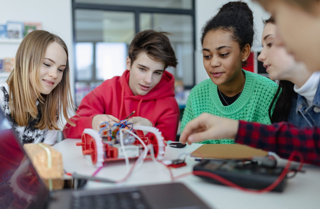 Group of diverse students collaborating on a STEM robotics project in a classroom setting.