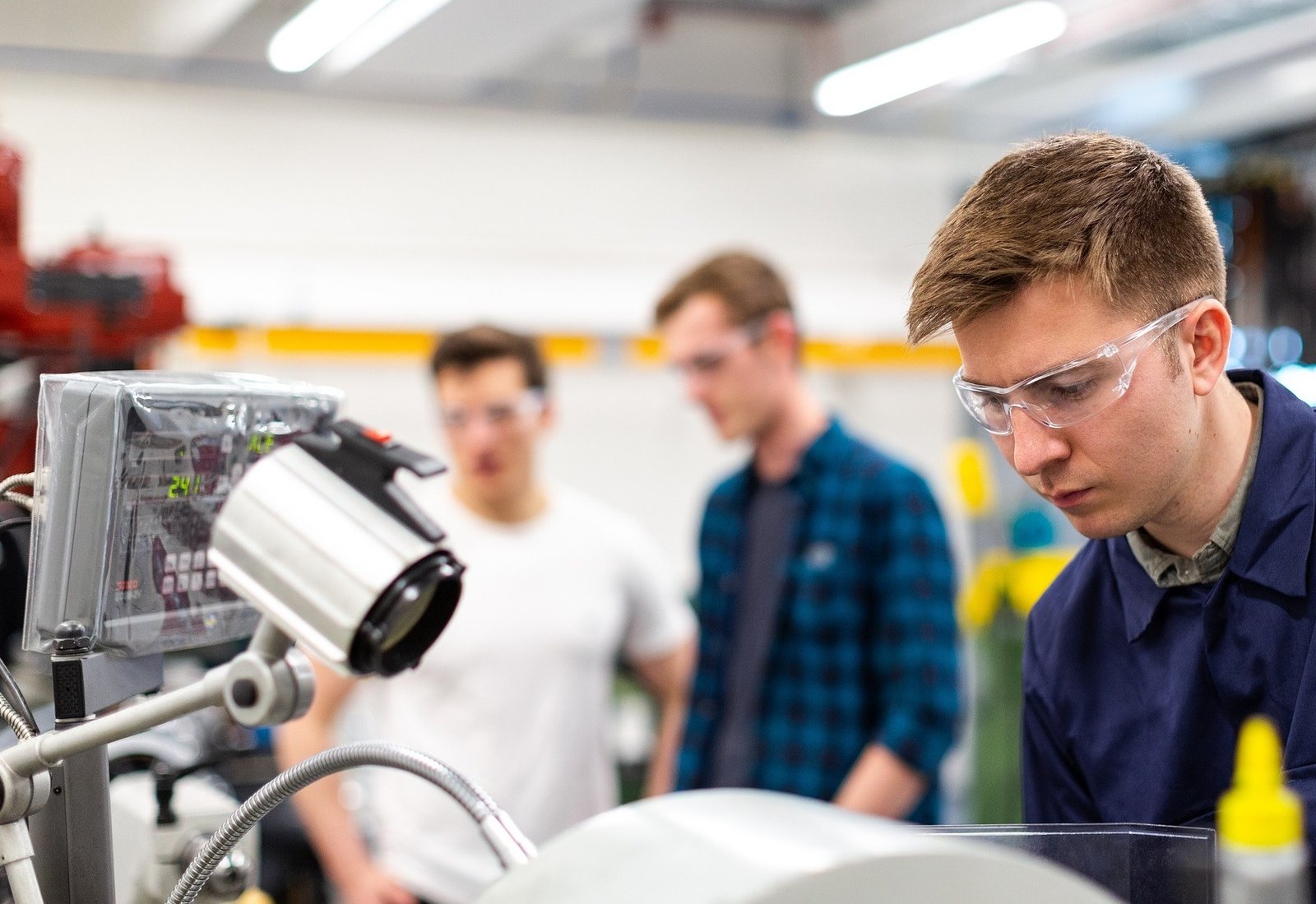 a man wearing goggles looking at a machine