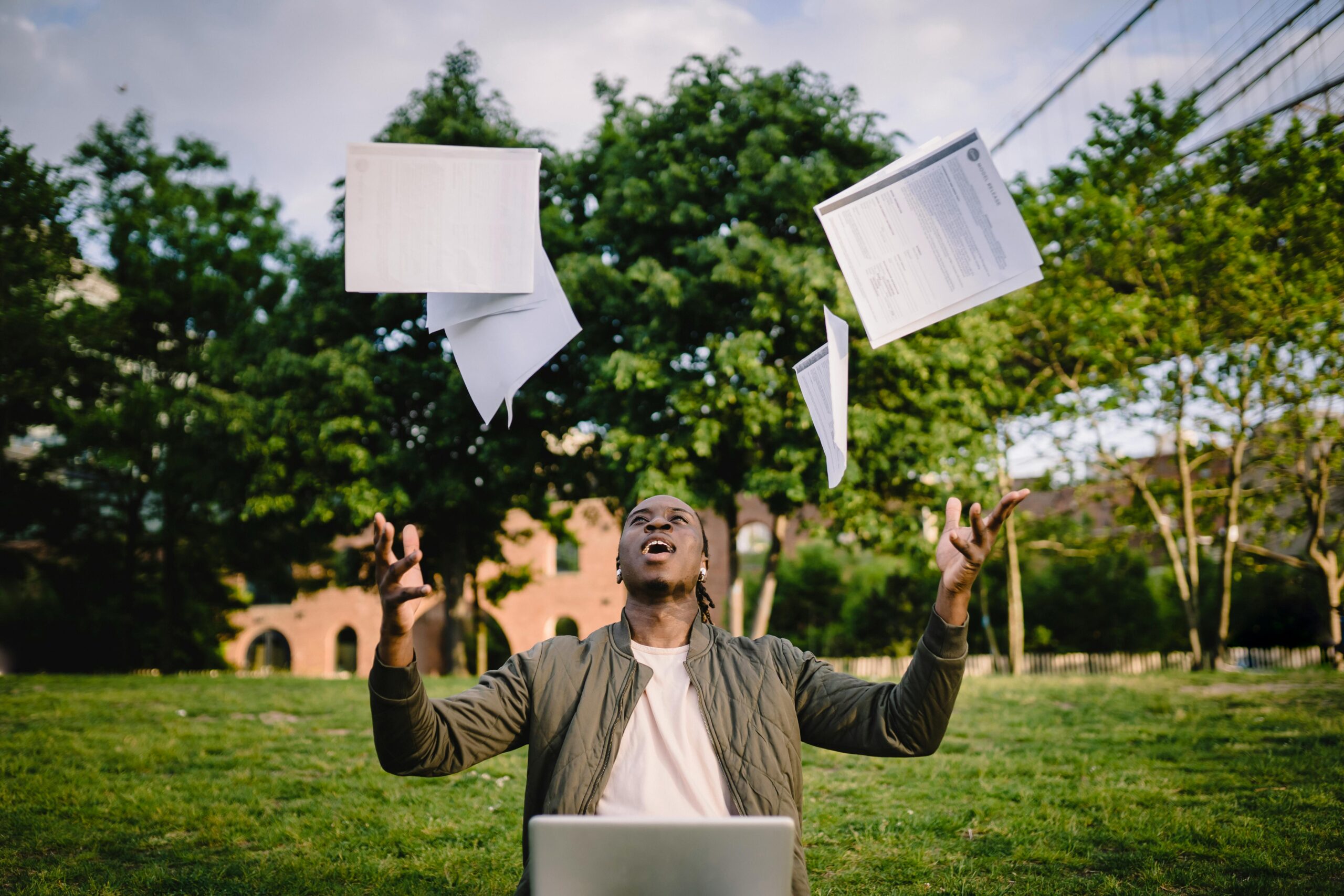 AI discovery course for Kids: A Complete Guide to Getting Started 18 Happy young black male freelancer throwing papers while celebrating successful project during remote work in green park