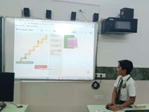 A student solving a Blockly puzzle on a smartboard in a STEM Lab in Delhi Schools.