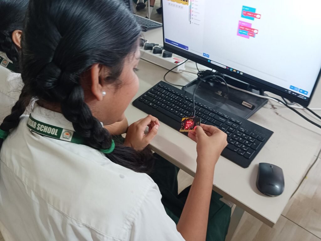 Girl using a microcontroller device in a STEM Lab in Delhi Schools.