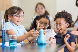 Student pouring colored liquid into a test tube during an experiment at a STEM Lab in Vadodara schools.